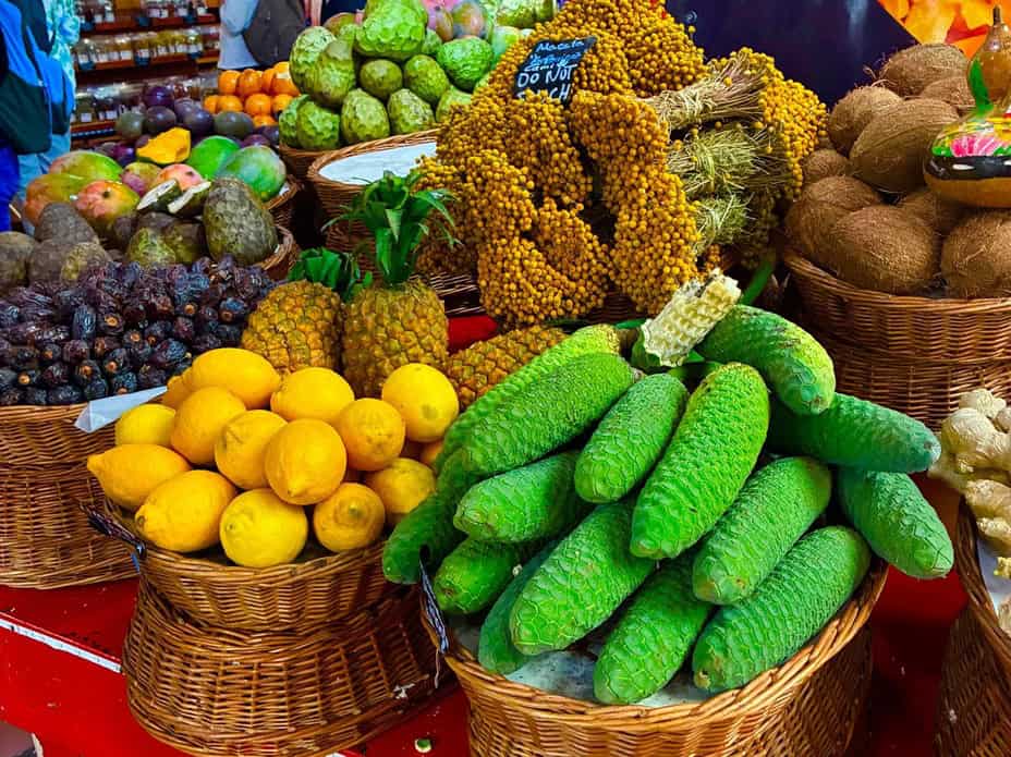 Manden met gekleurd fruit op de Mercado Dos Lavredores in Funchal, Madeira